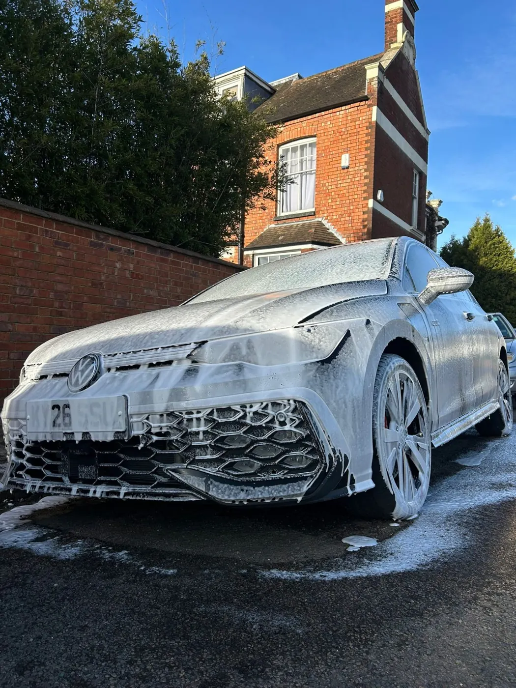 White Volkswagen covered in snow foam at the start of a Full Reset detail