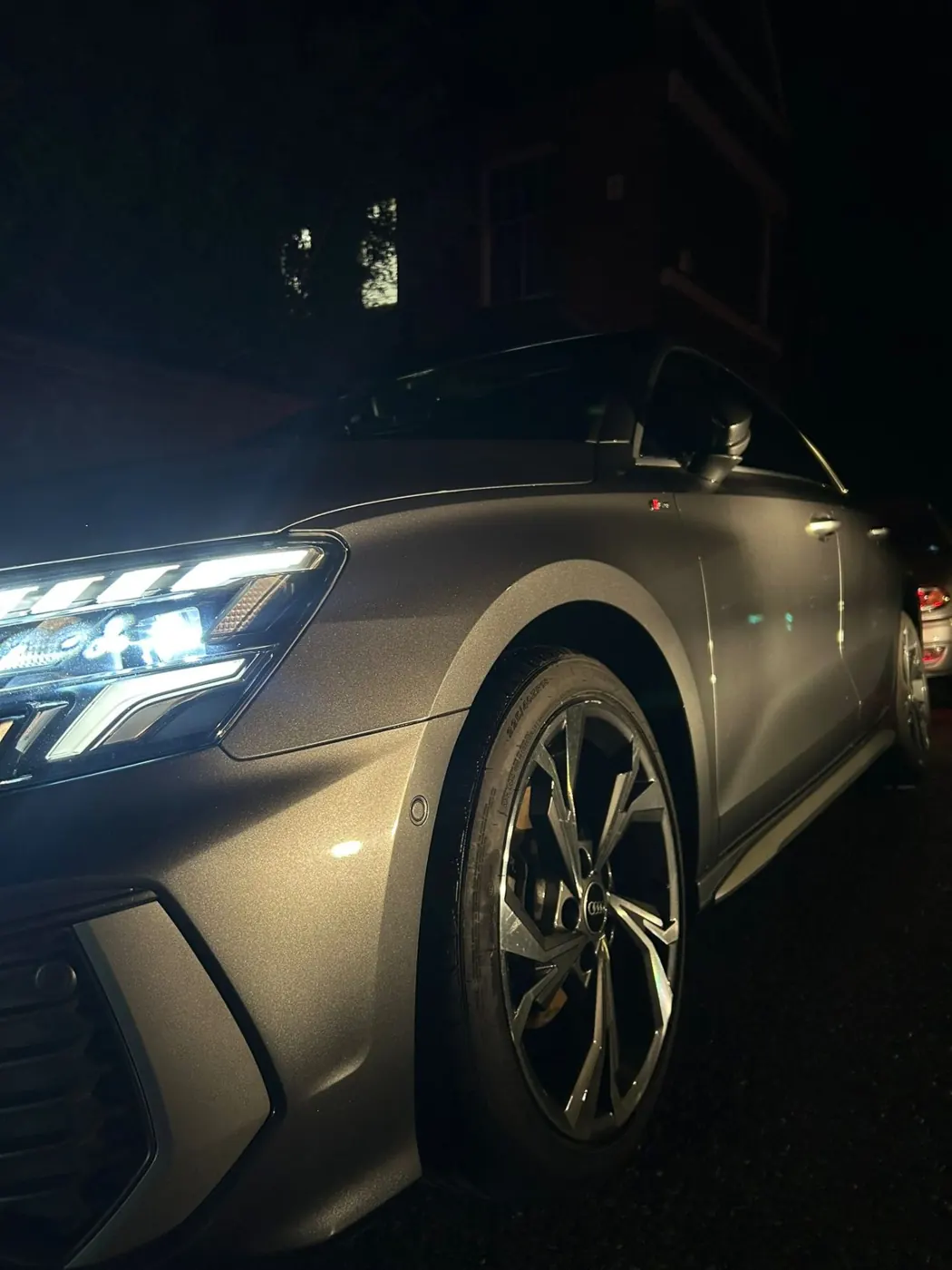 Freshly detailed Audi with headlights on at dusk