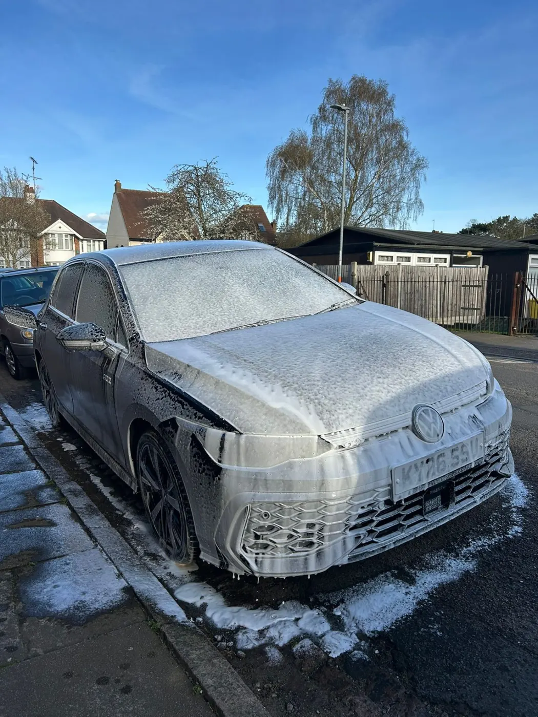 Snow-foamed Volkswagen Golf on a residential street in Northamptonshire